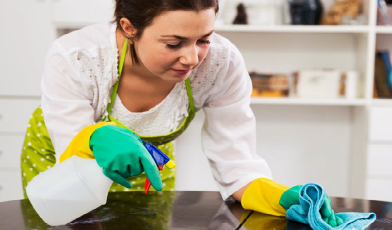 beautiful young woman wiping table with rag