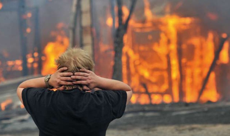 a young man getting upset to see the fire in the forest