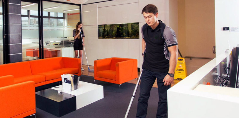 man and woman with mops scrubbing office floor