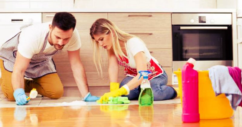 man and woman scrubbing hardwood floor