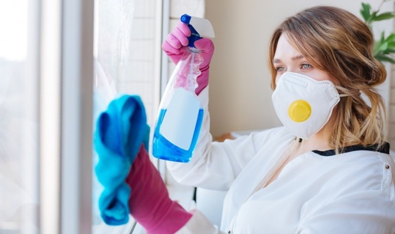 a beautiful woman is wiping a window glasses