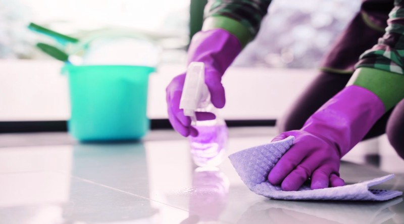 a man in purple gloves wiping the floor