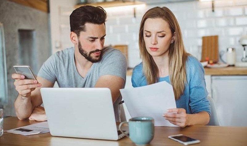 a young couple is reading an important document