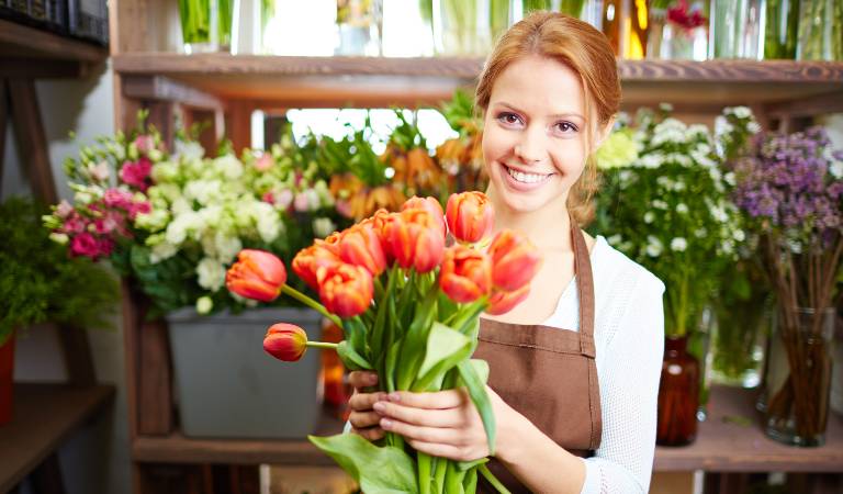 Woman holding plants in her hand and smiling