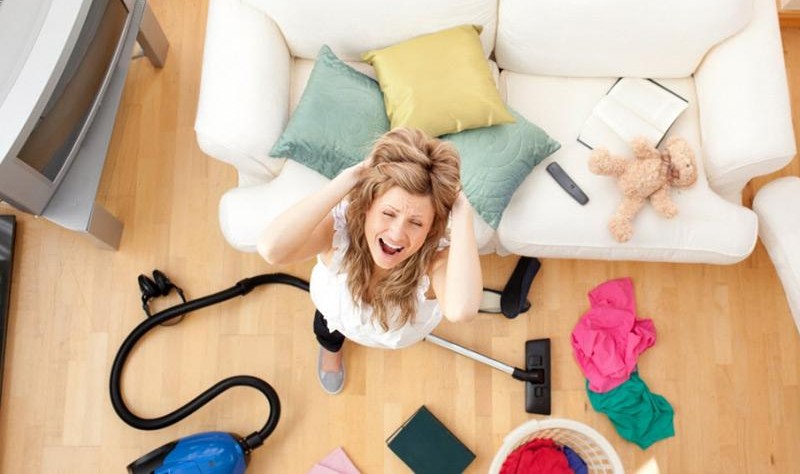 young woman looking angry about her messy house