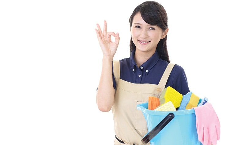 young woman holding a bucket full of scrubbers and cloth wipes