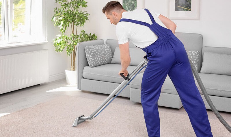 a young man vacuuming a carpet