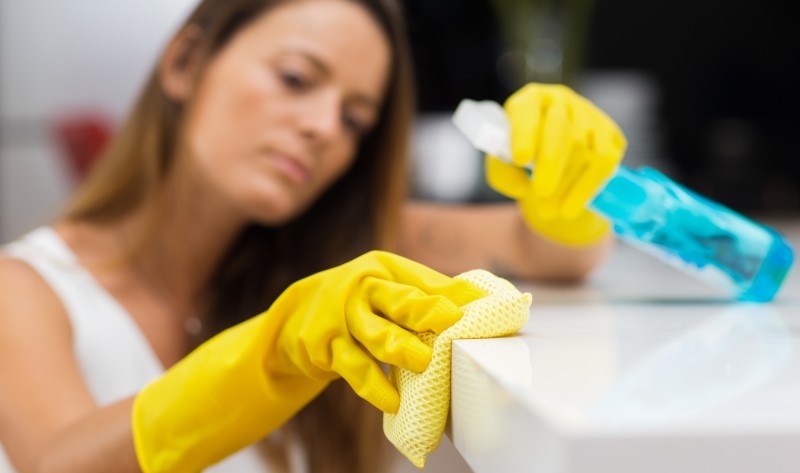 young woman disinfecting a surface