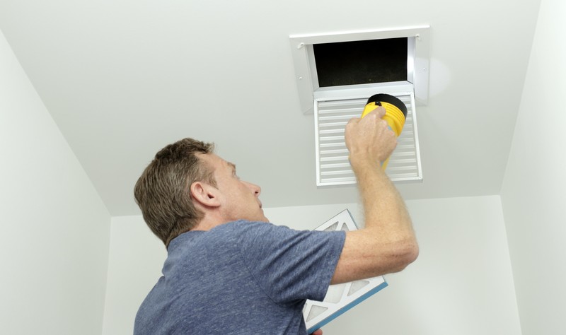 young man trying to fit an air duct