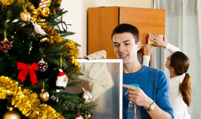 young couple sprucing up their house for christmas