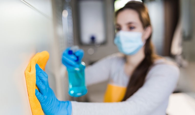 young woman disinfecting a surface