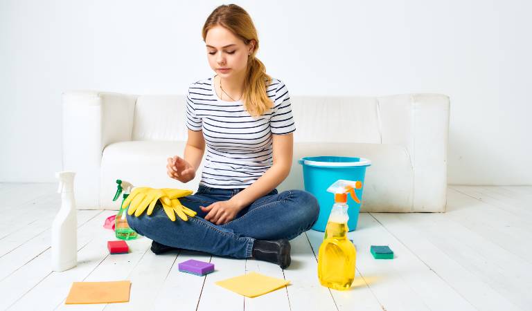 Woman in check t-shirt and jeans sitting with tools and supplies
