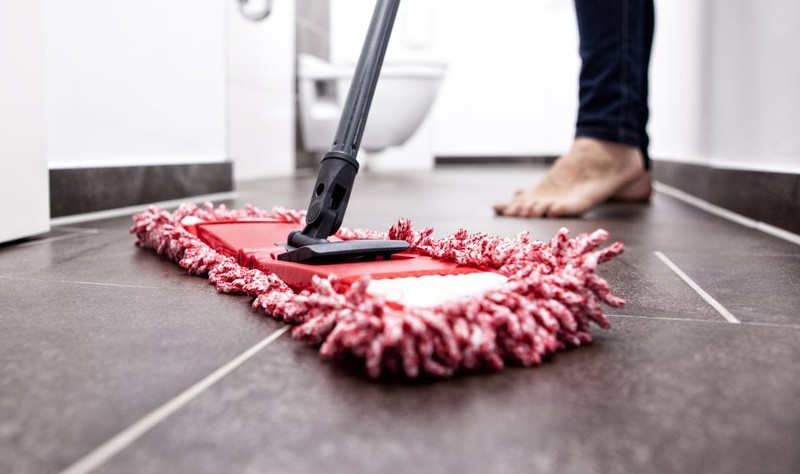 cropped picture of a woman moping the bathroom floor