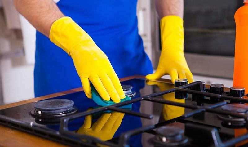 cropped picture of a professional moping a gas stove