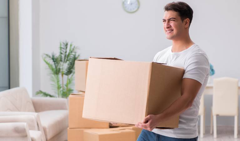 man in white t-shirt holding a box in his hand.