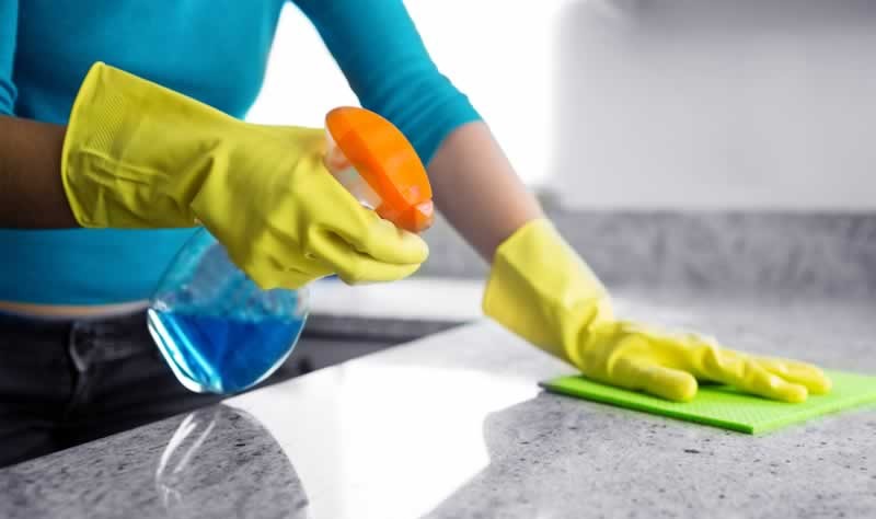 A girl is wiping the counter-top