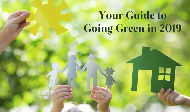 people holding cutouts of a family and green house