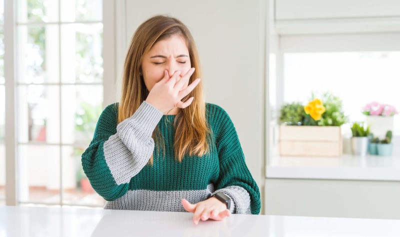 young woman covering her nose with her hand