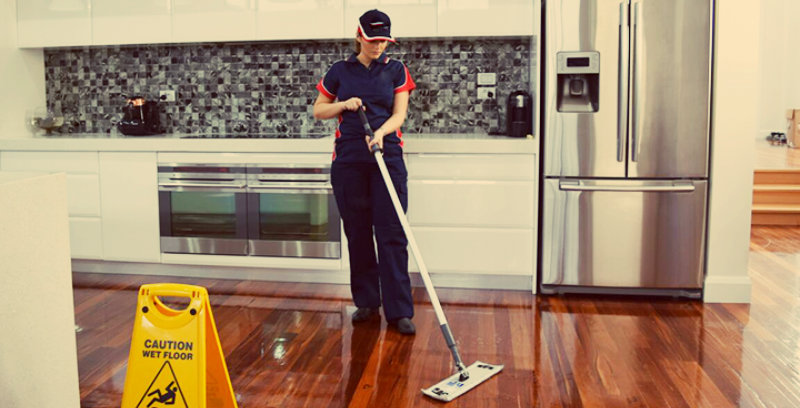 lady in blue dress wiping hardwood floor