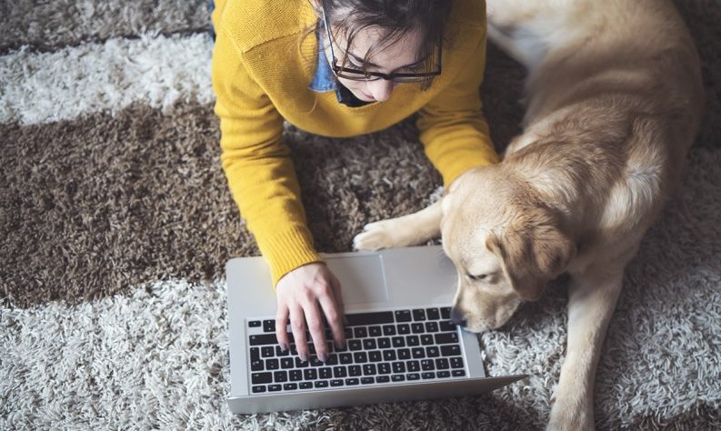 young woman sitting on the carpet with her dog