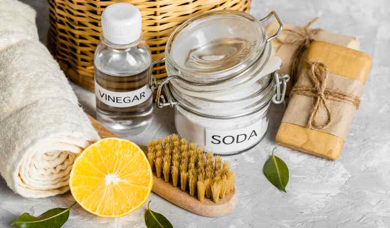 Lemon, baking soda, brush, towel on the table.