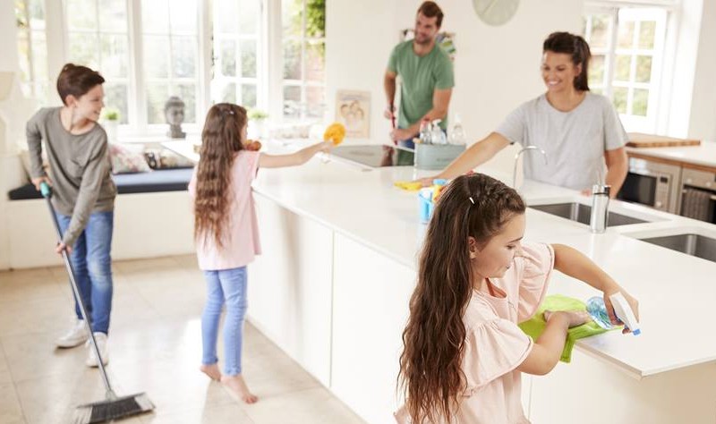 a family is dusting their kitchen and making it tidy