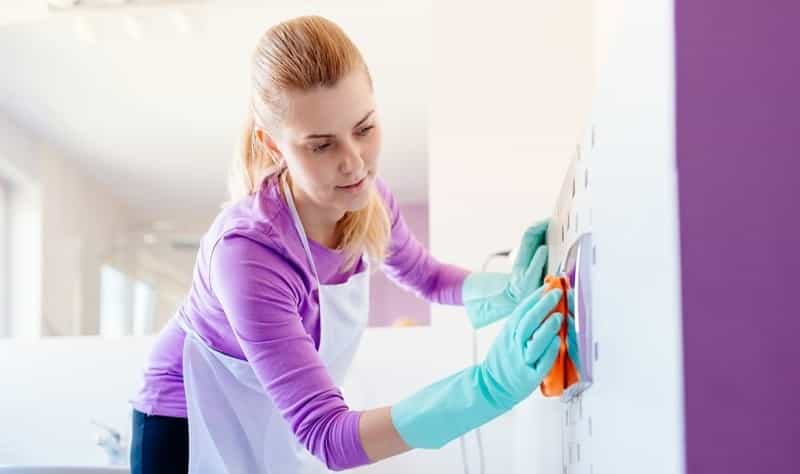 young woman disinfecting a surface