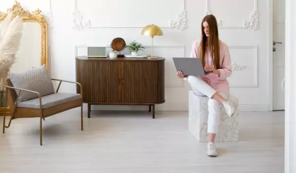 woman sitting inside of her house and working on a laptop