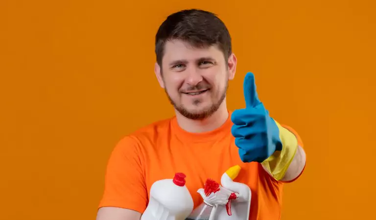 young man with cleaning supplies ready to clean house