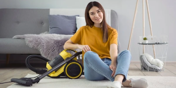 Lady on floor with a vacuum cleaner.