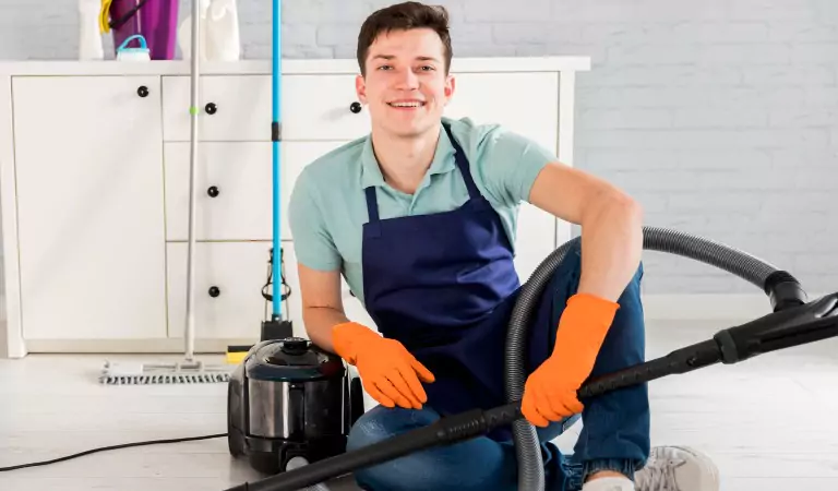 young man with a vacuum cleaner ready to clean his house