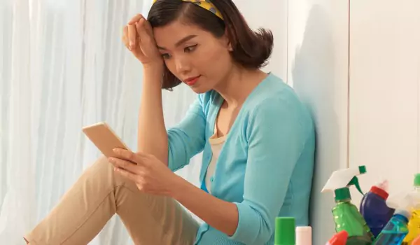 woman using a phone and sitting on the floor