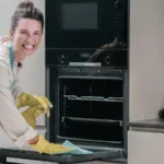woman cleaning kitchen appliance