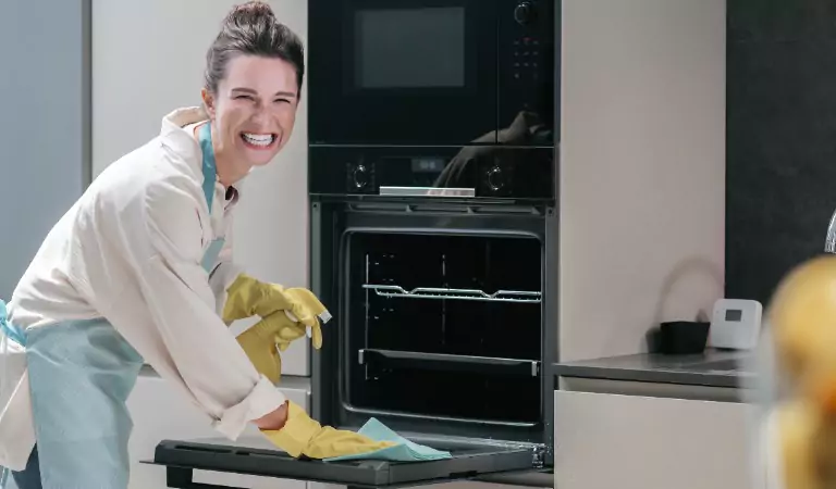 woman cleaning kitchen appliance