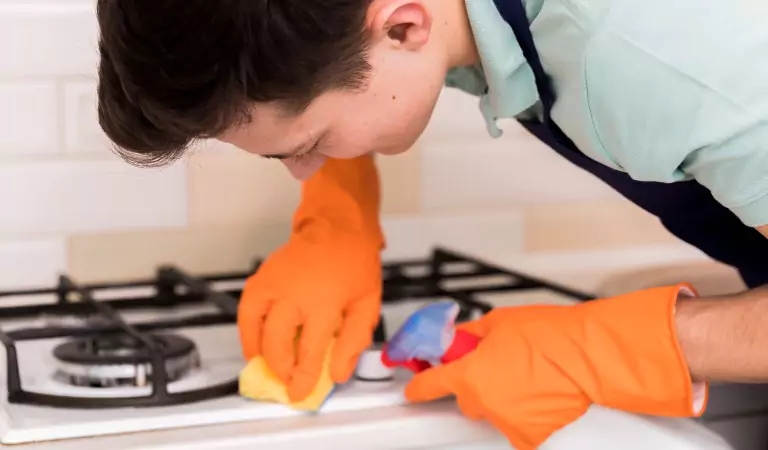 young man disinfecting a stovetop