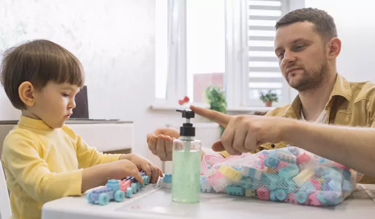 young man disinfecting the toys with sanitizer