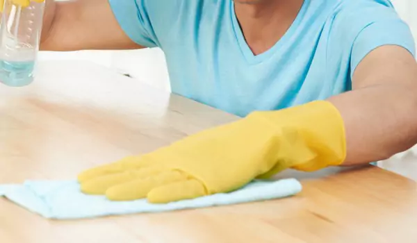 cropped picture of a person cleaning a wooden surface