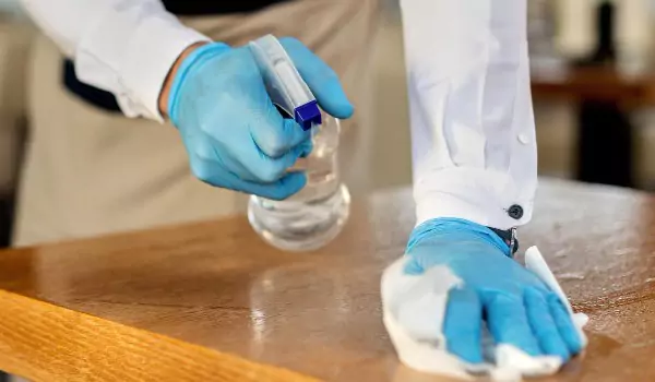 cropped picture of a person cleaning a wooden furniture