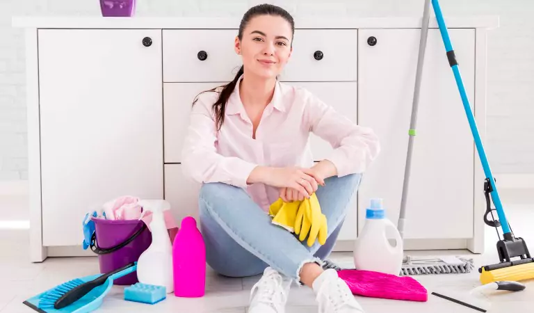 young woman inside of a house with some cleaning supplies