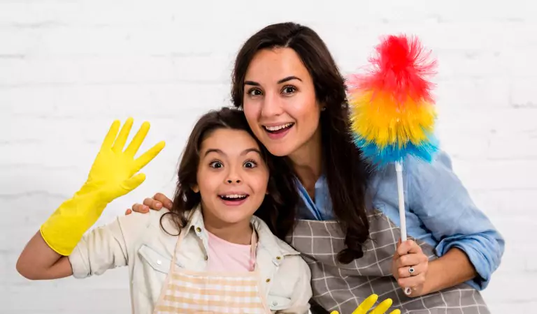 Woman with her daughter with a dusting tool enjoying while sprucing up their house