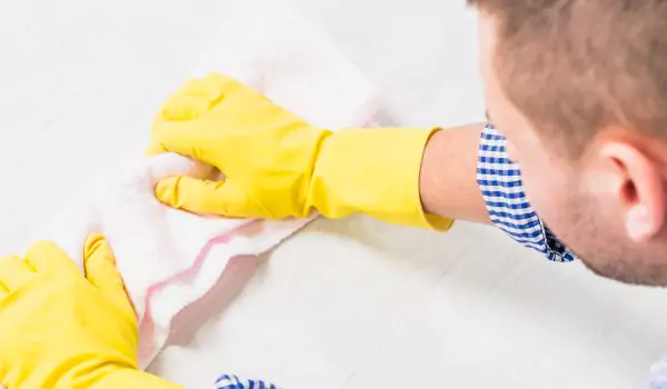 young man rubbing a floor stain