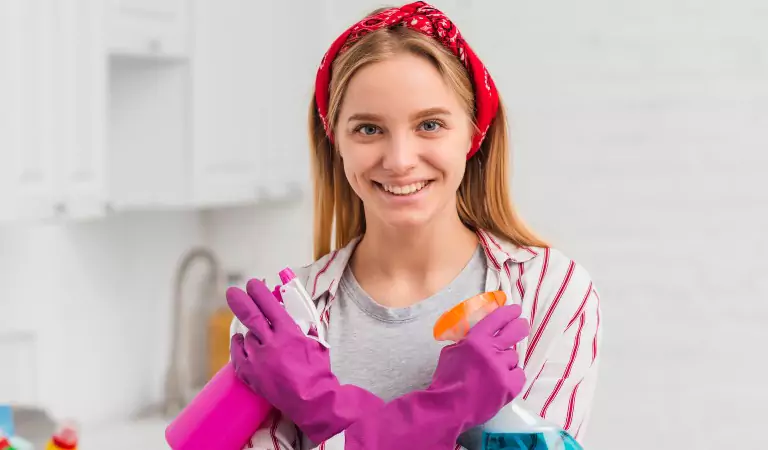 woman with cleaning spray ready to clean her house