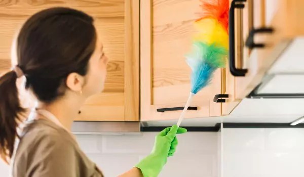 woman cleaning kitchen cabinet