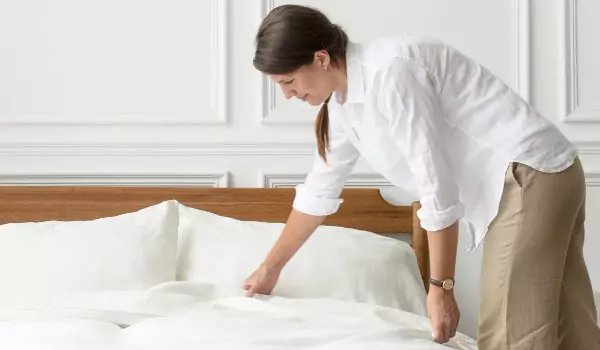 woman making a bed in her house
