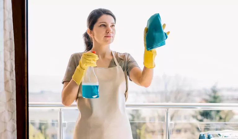 woman cleaning a window glass from the outside
