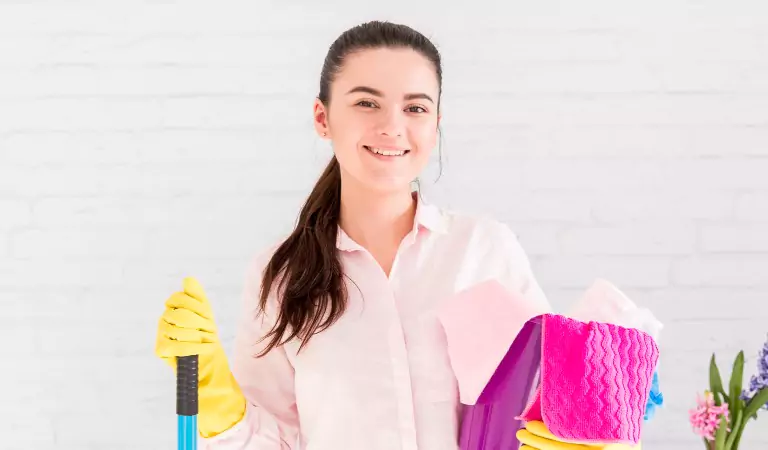 young woman with some cleaning supplies ready to clean her house