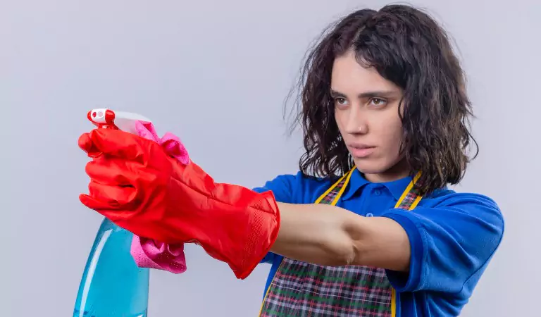 young woman with a cleaning spray ready to clean her house
