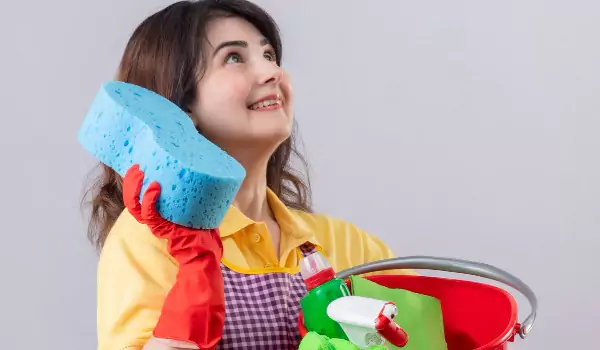 woman with some cleaning supplies posing for a photo