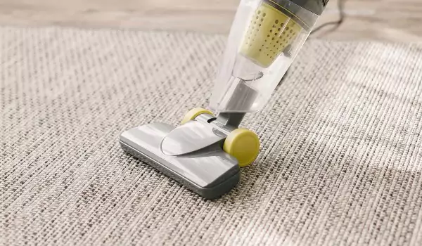 cropped picture of a person vacuuming a carpet