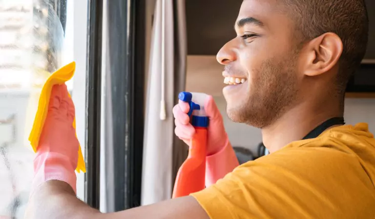 young man cleaning the window blinds